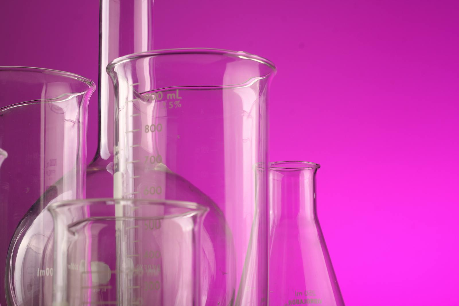 Empty clear glass laboratory flasks against a soft backdrop, evoking the SCCS scientific reviews that set EU paraben concentration limits