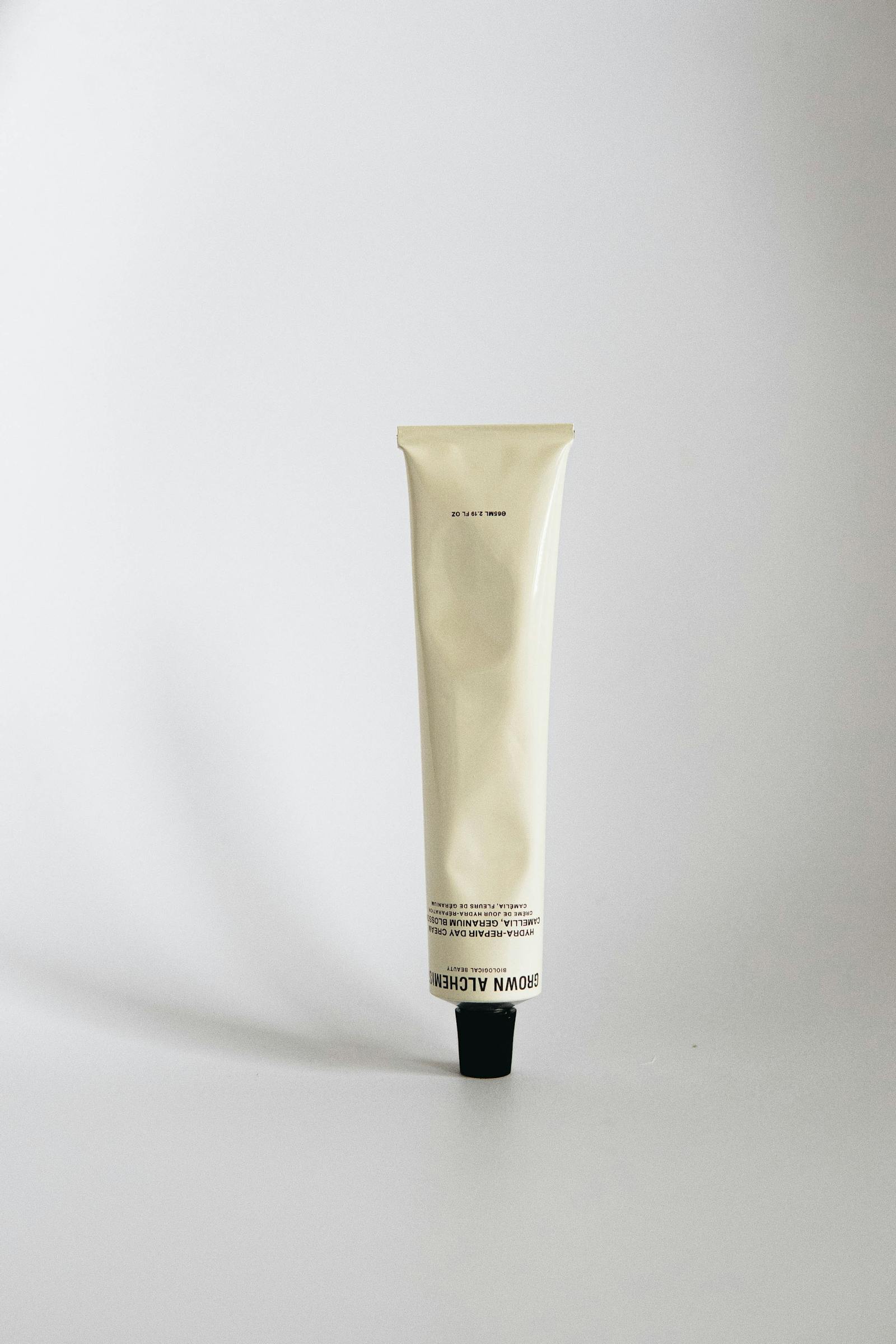 Plain white cosmetic cream tube on a neutral background, the kind of preserved formulation that paraben chemistry has protected for eighty years