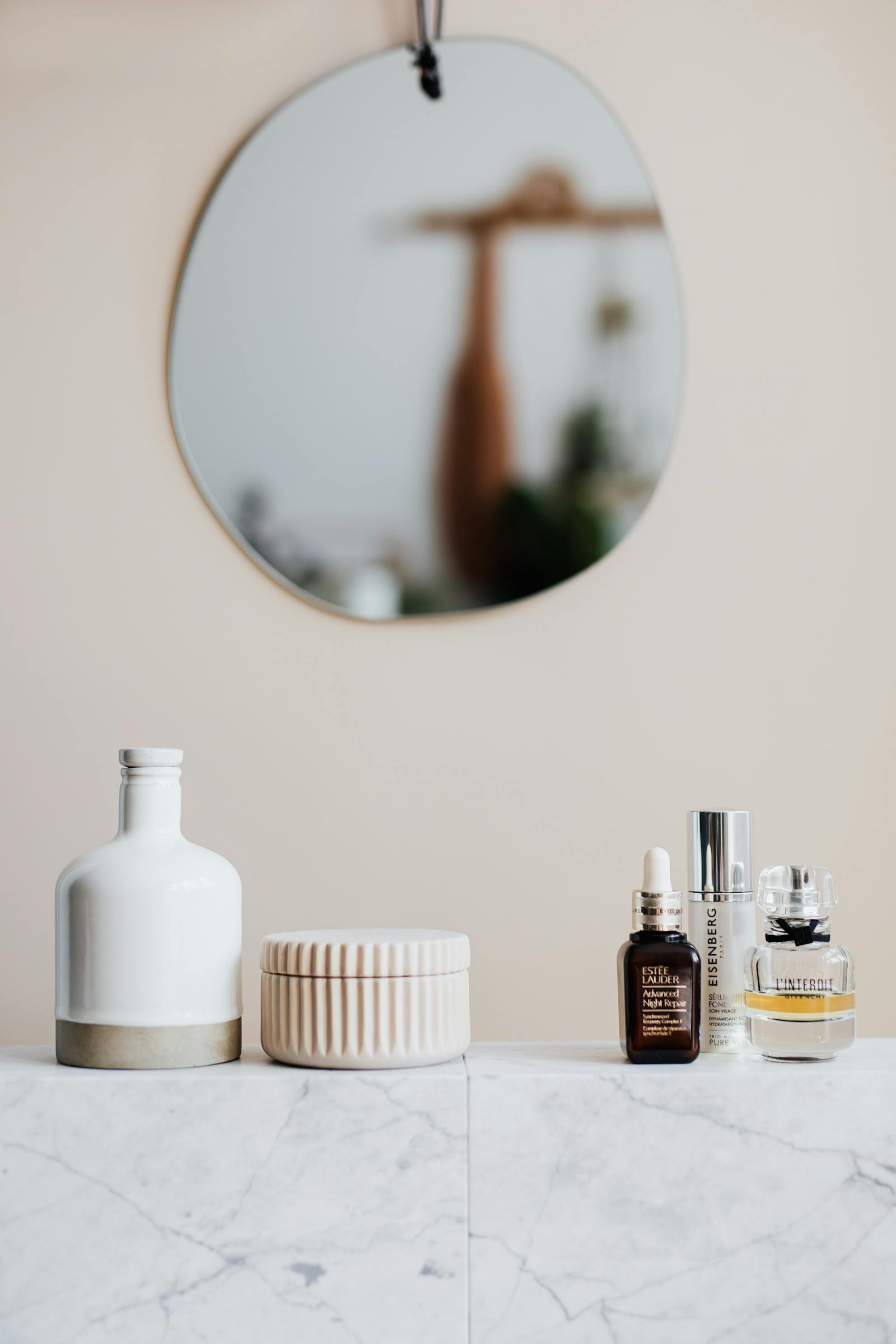 Vitamin C serums and skincare products arranged on a marble bathroom shelf